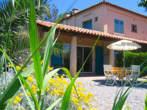une maison avec un parasol, une table et des chaises dans l'établissement Beau 3 pièces plage de Gigaro, WIFI, à La Croix-Valmer