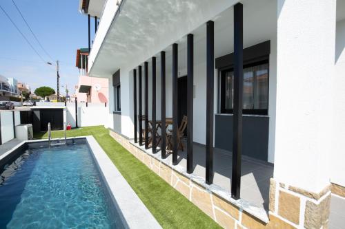 a swimming pool on the side of a house at Casa Caravelas - Matias Village in Praia da Areia Branca