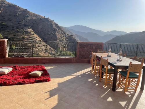 a patio with a table and chairs and a view at Issouganes N Toubkal Maison d hôtes in Oussertek