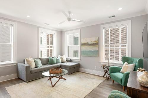 a living room with a couch and chairs and windows at The Cooper Suite at 122 Spring in Charleston