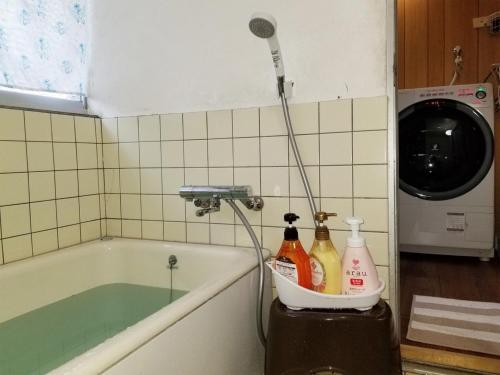 a bathroom with a bath tub with a blow dryer at Condominium Tsuwanosou - Vacation STAY 67529v in Tsuwano