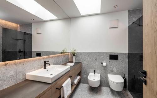 La salle de bains est pourvue d'un lavabo et de toilettes. dans l'établissement Residence Le Fostü, à San Vigilio Di Marebbe