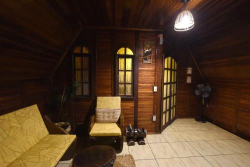 a living room with a couch and chairs in a house at Pousada Recanto das Aves in Iguape