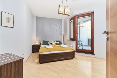a bedroom with a bed and a large window at Apartment Wrocław Krawiecka by Renters in Wrocław
