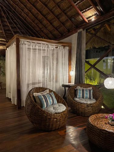 two wicker chairs and a table in a room at Cabañas Luxury con Lagoon Club - Adults Only in Bacalar