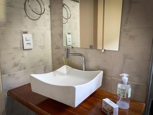a white sink on a wooden table in a bathroom at Sítio Colibri - Serra da Mantiqueira in Brazópolis