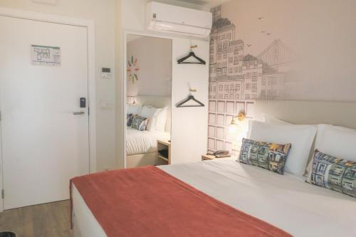 a bedroom with a white bed with a red blanket at Mouraria Lisboa Hotel in Lisbon