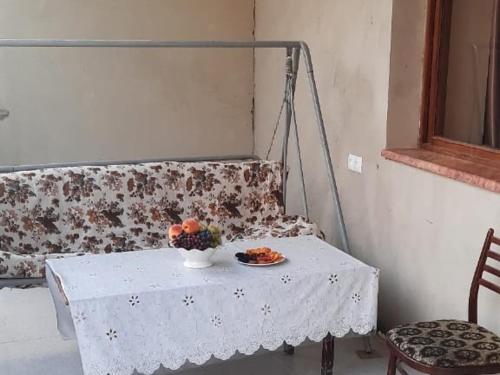 a white table with a bowl of fruit on it at Anna Home B&B in Areni