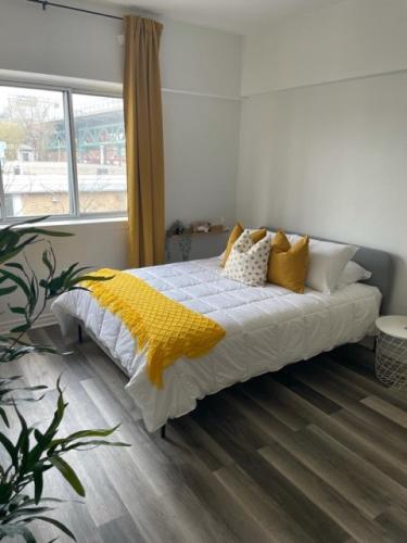 Un dormitorio con una cama con una manta amarilla. en Faubourg Ste Cath, en Montreal