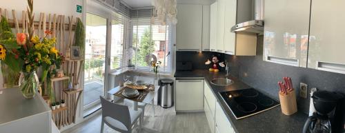a kitchen with white cabinets and a black counter top at TOP appartement met garage "Au Franelle" in Ostend