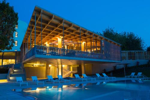 a building with chairs and a swimming pool at night at OZADI Tavira Hotel in Tavira