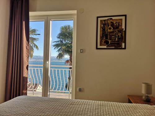 a bedroom with a bed and a view of the ocean at Apartments Mira in Medveja