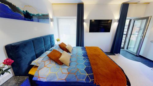 a bedroom with a blue bed with pillows at Ferienhof A&B Wellness Villa 12 personen in Bullange