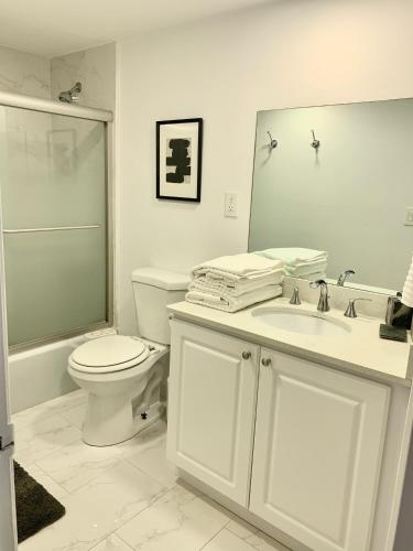 a bathroom with a toilet and a sink and a mirror at Miami Sunny Isles ocean reserve 704 in Miami