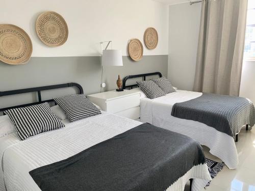 2 łóżka w białym pokoju z czarno-białą pościelą w obiekcie Miami Sunny Isles ocean reserve 704 w Miami