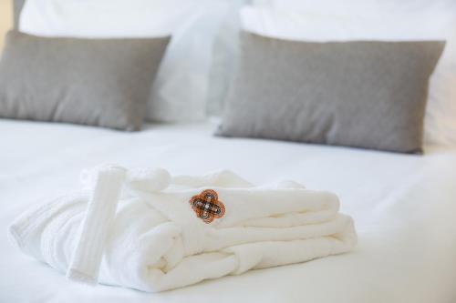 a ring on a pile of towels on a bed at OZADI Tavira Hotel in Tavira