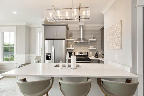 a kitchen with a large white island with chairs at The Magnolia Suite at 124 Spring in Charleston