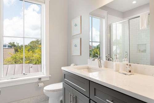 a white bathroom with a sink and a toilet at The Magnolia Suite at 124 Spring in Charleston