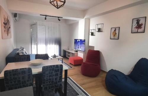 een woonkamer met een tafel en stoelen bij LYNX Apartments in Ohrid