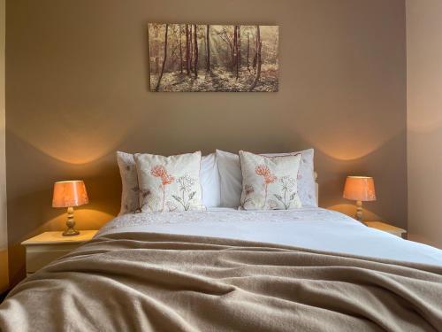 a bed with a white bedspread and pillows at Greenfields Country House in Latton