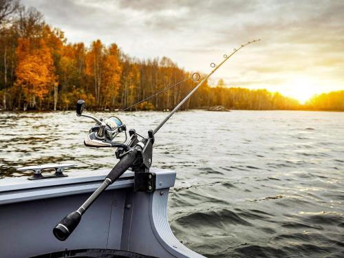 a fishing rod on the side of a boat on a lake at Vintage Forest Retreat-By Traum in Rörbäcksnäs