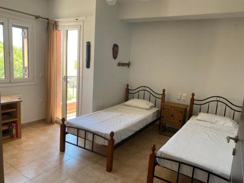 a bedroom with two beds and a window at 350m Above Sea in Vasiliki