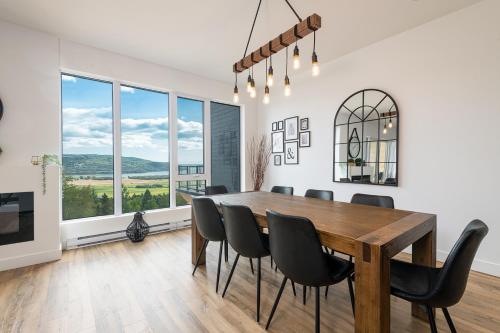 una sala da pranzo con tavolo e sedie in legno di La Pignoronde a Baie-Saint-Paul