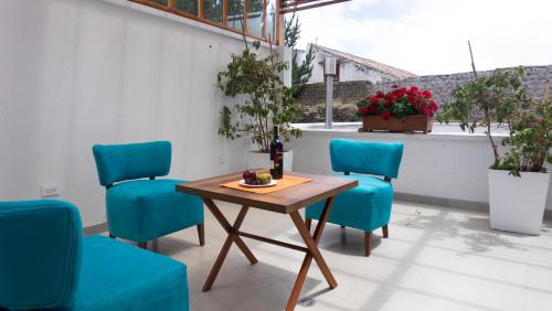 a table and four blue chairs on a patio at REEC Latacunga by Oro Verde Hotels in Latacunga