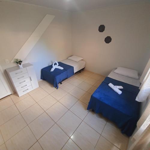 a small room with two beds and a black spot on the wall at CASA DU VÔ - Cantinho Du Vô in Santa Teresa