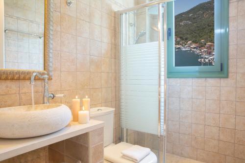 łazienka z umywalką, toaletą i oknem w obiekcie Ktima Aniforeli Luxury Villas w mieście Sivota