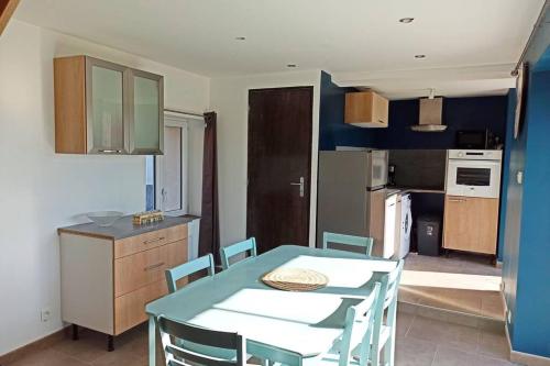 une cuisine avec une table et des chaises dans une cuisine dans l'établissement Petite maison de charme, à Doué-la-Fontaine