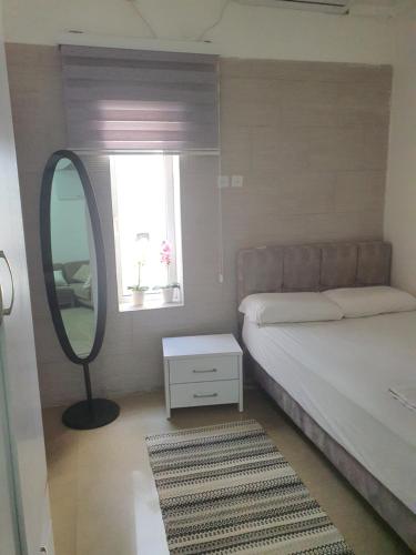 una camera con letto, specchio e finestra di Laila's studio a Haifa