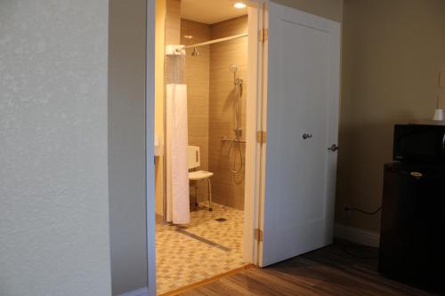 une porte ouverte menant à une salle de bains pourvue d'une douche. dans l'établissement Imperial Inn Oakland, à Oakland