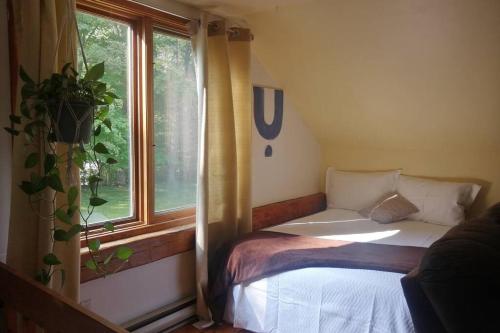 a small room with a bed and a window at L'Alcôve des Céramistes in Waterloo