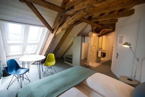 a room with a bed and a table and chairs at Gasthaus zum Trauben in Weinfelden