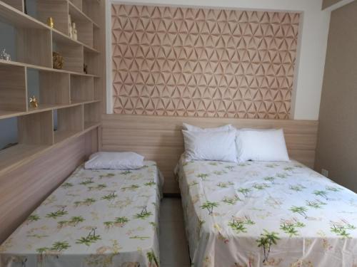 1 Schlafzimmer mit 2 Betten und einer Wand in der Unterkunft Flat Olímpia com Área de Churrasqueira privada e tudo novo in Olímpia