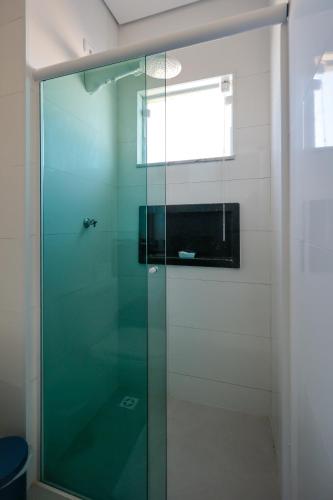 a shower with a glass door in a bathroom at Peruibiza Pousada in Peruíbe