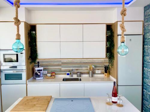 a kitchen with white cabinets and a sink at Villa Blanca Tenerife - Atico Loft in San Isidro