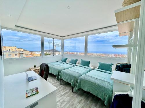 two beds in a room with large windows at Villa Blanca Tenerife - Atico Loft in San Isidro