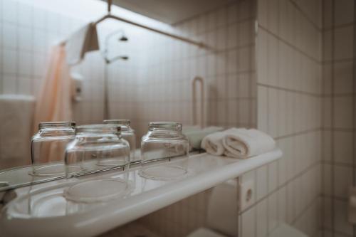 Un mostrador de baño con tres frascos de cristal. en Hótel Skálholt en Skálholt