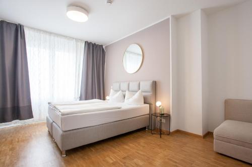 a white bedroom with a bed and a window at TM Hotel Düsseldorf in Düsseldorf
