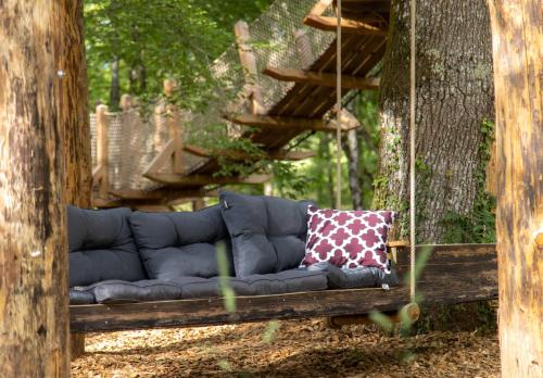 a blue couch sitting in front of a tree at Nid'en'Ô cabanes et spa Lot et Dordogne in Lamothe-Fénelon