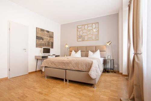 a bedroom with a large bed and a desk at TM Hotel Düsseldorf in Düsseldorf