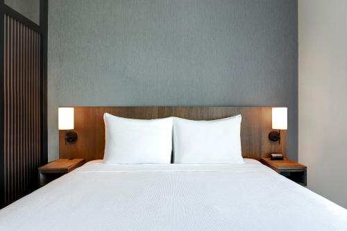 a bedroom with a large white bed with two night stands at Hyatt Place Ottawa West in Ottawa