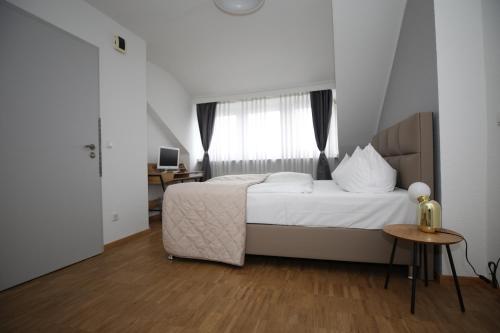 a bedroom with a bed and a desk and a window at TM Hotel Düsseldorf in Düsseldorf