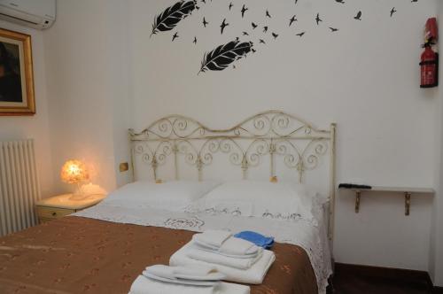 a bedroom with a white bed with towels on it at La casa di Luna in San Benedetto del Tronto