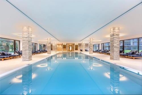 einen Pool in einem Gebäude mit Stühlen in der Unterkunft Dolomitengolf Suites in Lavant