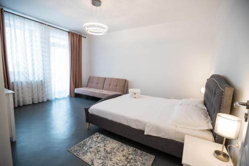 a bedroom with a large bed and a chair at City View in Turda