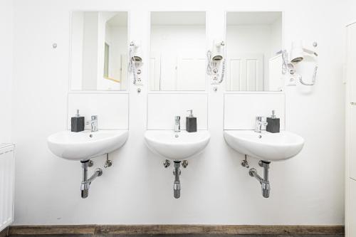 a bathroom with two sinks and mirrors on the wall at Space Home Apartment - City Center in Vienna
