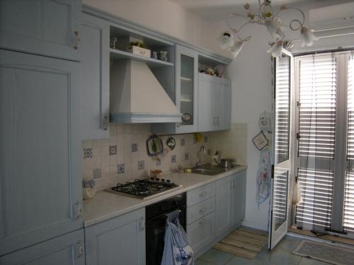 una cucina con armadi bianchi e piano cottura di Casuzze Country a Marina di Ragusa